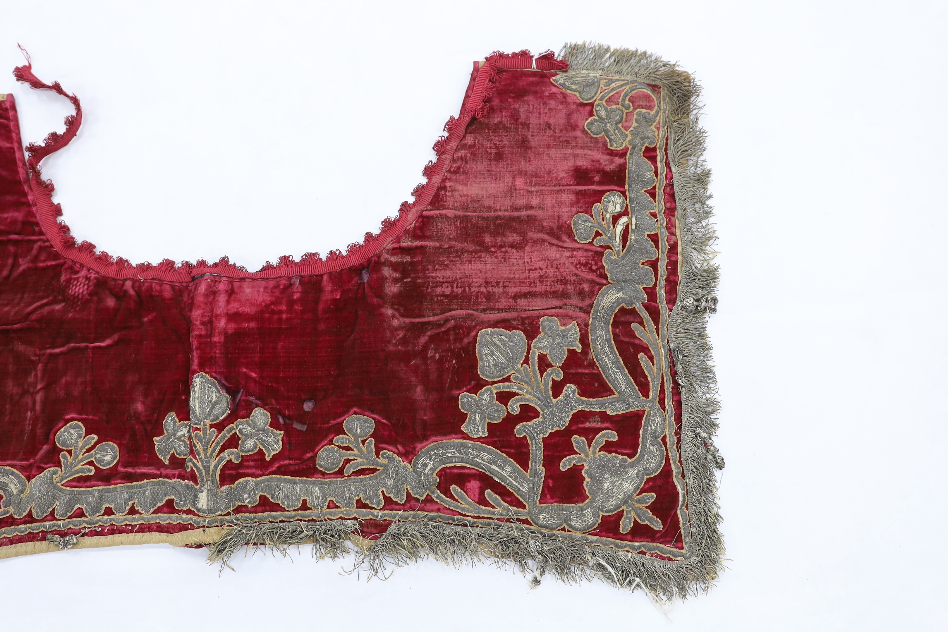 A burgundy velvet and silver thread embroidered and fringed saddle blanket, possibly Italian or Spanish, circa late 18th century, 94cm long x 50cm deep